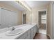 Bright bathroom featuring a long vanity with double sinks, large mirror, and natural light at 160 Fox Run Rd, Youngsville, NC 27596