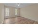 Bedroom with neutral walls, light-colored wood floors, and two large windows at 160 Fox Run Rd, Youngsville, NC 27596
