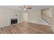 A bright living room featuring a fireplace, ceiling fan, and staircase at 160 Fox Run Rd, Youngsville, NC 27596
