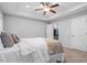 Bright bedroom with a ceiling fan, neutral walls, and a doorway leading to a walk-in closet at 162 W Lumber Ct, Clayton, NC 27520