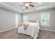 Bright bedroom with tray ceiling, carpeted floors, two windows, and ensuite bath access at 162 W Lumber Ct, Clayton, NC 27520