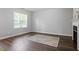 Neutral bedroom with wood floors, fireplace, and window with blinds; carpeted floor with rug detail at 162 W Lumber Ct, Clayton, NC 27520
