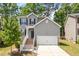 Charming two-story home with gray siding, white trim, landscaped front yard, and attached two-car garage at 162 W Lumber Ct, Clayton, NC 27520