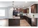 Modern kitchen featuring dark wood cabinets, granite countertops, a central island, and stainless steel appliances at 162 W Lumber Ct, Clayton, NC 27520