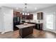 Modern kitchen featuring dark wood cabinetry, granite counters, stainless steel appliances, and a center island at 162 W Lumber Ct, Clayton, NC 27520