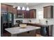 Modern kitchen featuring dark wood cabinets, granite countertops, a central island, and stainless steel appliances at 162 W Lumber Ct, Clayton, NC 27520