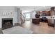 Open-concept living space featuring wood floors, fireplace, staircase, and kitchen with island and black appliances at 162 W Lumber Ct, Clayton, NC 27520