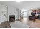 Open-concept space with fireplace, built-ins, dark wood floors, staircase, and kitchen featuring an island at 162 W Lumber Ct, Clayton, NC 27520
