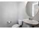 Simple powder room with pedestal sink, round mirror, neutral walls, and toilet at 162 W Lumber Ct, Clayton, NC 27520