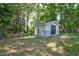 Backyard shed with double doors in a wooded, fenced backyard at 1708 S Alston Ave, Durham, NC 27707