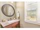 Powder room features granite countertop, bronze faucet and hardware, and a framed circular mirror at 1710 Eddy Ct, Franklinton, NC 27525