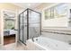 This bathroom features a tub, separate glass enclosed shower and window with view of the yard at 1710 Eddy Ct, Franklinton, NC 27525