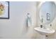 Chic powder room with a pedestal sink, round mirror, and modern fixtures at 19 Sangre De Cristo Dr, Durham, NC 27705