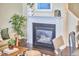 Cozy living room fireplace with a white mantel and black surround, decorated with plants and art at 19 Sangre De Cristo Dr, Durham, NC 27705