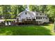 Rear view showing a deck, patio area, and large backyard with mature trees at 202 Homestead Dr, Cary, NC 27513