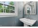 Powder room featuring a pedestal sink, mirror, and a window overlooking the outdoors at 202 Homestead Dr, Cary, NC 27513