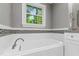 Clean bathroom with tub, mosaic backsplash, and white cabinets at 202 Homestead Dr, Cary, NC 27513