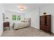 Inviting bedroom with neutral carpet, natural light, a tufted bed, and a wooden dresser at 202 Homestead Dr, Cary, NC 27513