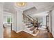 Elegant foyer featuring hardwood floors, a staircase, and decorative lighting at 202 Homestead Dr, Cary, NC 27513