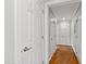 Hallway features a hardwood floor, white walls, with several doors leading to various rooms at 202 Homestead Dr, Cary, NC 27513