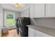 Bright laundry room with modern washer and dryer, white cabinets, and a view of the outdoors at 202 Homestead Dr, Cary, NC 27513