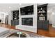 Cozy living room featuring a brick fireplace, built-in shelving, and a mounted television at 202 Homestead Dr, Cary, NC 27513