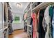 Spacious walk-in closet featuring custom shelving, drawers, hardwood floors and a window overlooking the yard at 202 Homestead Dr, Cary, NC 27513