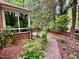 Landscaped backyard features a brick pathway, mature plantings, and a privacy fence at 204 N Elliott Rd, Chapel Hill, NC 27514