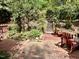 Lush backyard features brick patio with chairs, stone steps, and mature trees for privacy at 204 N Elliott Rd, Chapel Hill, NC 27514
