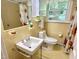 Well-lit bathroom featuring a sink and toilet with yellow-toned tiling and classic design at 204 N Elliott Rd, Chapel Hill, NC 27514