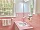 Bathroom showcasing a sink with vanity, light pink tile, and a window with natural light at 204 N Elliott Rd, Chapel Hill, NC 27514