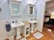 Charming bathroom with dual pedestal sinks, beadboard paneling, and classic fixtures, offering timeless appeal at 204 N Elliott Rd, Chapel Hill, NC 27514