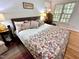 Comfortable bedroom with a floral-patterned bedspread, natural light, and hardwood floors creating a cozy atmosphere at 204 N Elliott Rd, Chapel Hill, NC 27514