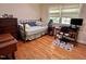 Bedroom with neutral walls, hardwood floors, decorative rug, and natural light from large windows at 204 N Elliott Rd, Chapel Hill, NC 27514