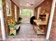 Inviting covered porch with brick flooring, decorative bench, potting table, and peaceful view at 204 N Elliott Rd, Chapel Hill, NC 27514
