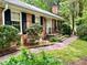 Charming brick home featuring black shutters, brick walkway, and professionally landscaped yard at 204 N Elliott Rd, Chapel Hill, NC 27514