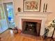 Classic fireplace with brick surround, white mantle, and doorway to sunroom at 204 N Elliott Rd, Chapel Hill, NC 27514