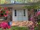 Charming brick home featuring a white front door flanked by sidelights and surrounded by vibrant pink azaleas at 204 N Elliott Rd, Chapel Hill, NC 27514