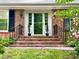 Charming front entrance featuring brick steps, iron railings and decorative black shutters at 204 N Elliott Rd, Chapel Hill, NC 27514