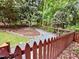 Backyard garden path with pea gravel, lush trees, and mature landscaping, enclosed by picket fence at 204 N Elliott Rd, Chapel Hill, NC 27514