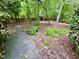 Serene garden path with pea gravel, mature trees, and natural landscaping providing a peaceful escape at 204 N Elliott Rd, Chapel Hill, NC 27514