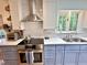 Well-lit kitchen with stainless steel appliances, blue cabinets, white subway tiles, and a functional layout at 204 N Elliott Rd, Chapel Hill, NC 27514