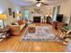 Inviting living room featuring hardwood floors, ceiling fan, and a cozy fireplace at 204 N Elliott Rd, Chapel Hill, NC 27514