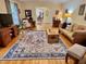 Spacious living room with hardwood floors, area rug, ceiling fan, and fireplace at 204 N Elliott Rd, Chapel Hill, NC 27514