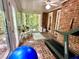 Cozy sunroom with brick floors, exercise equipment, and inviting seating, ideal for relaxation or workouts at 204 N Elliott Rd, Chapel Hill, NC 27514
