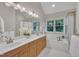 Bright bathroom featuring a soaking tub, shower and dual sink vanity with a large window at 206 Wagon Trail Dr, Cary, NC 27513