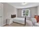 Modest bedroom featuring a wooden bed frame, white dresser and bright window at 206 Wagon Trail Dr, Cary, NC 27513