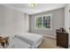 This neutral bedroom features a bed, dresser and a window with green outdoor views at 206 Wagon Trail Dr, Cary, NC 27513
