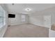 A large, empty bedroom with neutral paint, carpet, a window and a wall-mounted tv at 206 Wagon Trail Dr, Cary, NC 27513