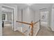 Upstairs hallway with wood railing and white spindles, offering access to multiple rooms at 206 Wagon Trail Dr, Cary, NC 27513
